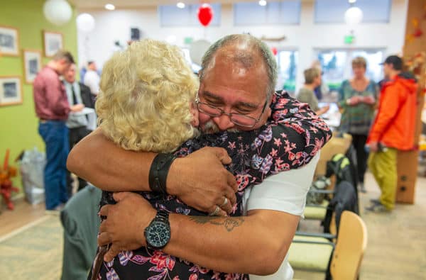Tribal Elder Eli Darien receives a hug at a ceremony for the first group of graduates from Henu Community Wellness Court.