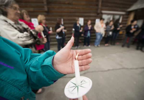 A participant in a candlelight vigil to remember victims of sexual assault shields her tiny flame from the wind outside Tyotka's Elder Center in Old Town Kenai. After a long moment of silence, participants took turns honoring family, friends and themselves. Nearly two dozen people attended the event.