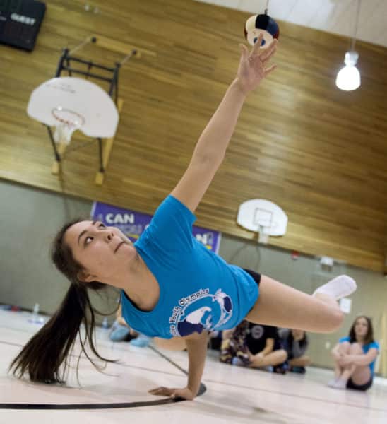 Chickaloon's Misty May Agoff competes Saturday morning in the one-hand reach event at the tribe's Native Youth Olympics Invitational held at Mountain View Elementary School in conjunction with the Peninsula Winter Games. Competitors have to balance on one hand, reach up and touch the bag, then return to balance.