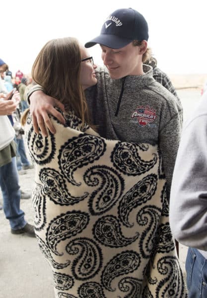 Cheyenne Wilson and her boyfriend Jakeb O'Brien huddle under a blanket while waiting for food.