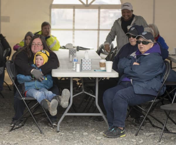 Members of the audience sit under heated tents to listen watch performances during the opening of the net ceremony.