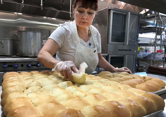 Carey Edwards butters buns hot out of the oven Monday, March 21, 2016, in the kitchen at the Kenaitze Indian Tribe's new Tyotkas Elder Center. She said she's happy to have an oven that will allow her to bake the way she likes to bake for the tribe's Elders.