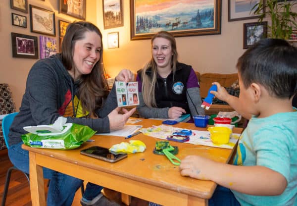 Kenaitze's Abby Hanna, center, laughs as Sandi Semaken uses flash cards with her son Samuel during an Early Head Start home visit.