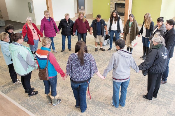 OUR VALUES: BELIEFS - Sharon Isaak (bottom right, grey jacket) leads members of the Kenaitze Indian Tribe's Elders Committee in a closing prayer after the group toured for the first time the tribe's new Elders building on Feb. 11, 2016.
