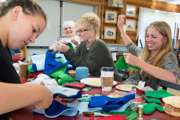 OUR VALUES: FAMILY-Nadia Walluk concentrates on her sewing as Alexandra (Sasha) Lindgren, Lindgren's daughter Kim Sweet, and granddaughter Shayna Franke share a laugh while working on ornaments for the U.S. Capitol Christmas Tree at the Kenaitze Indian Tribe's Tyotka's Elder Center.