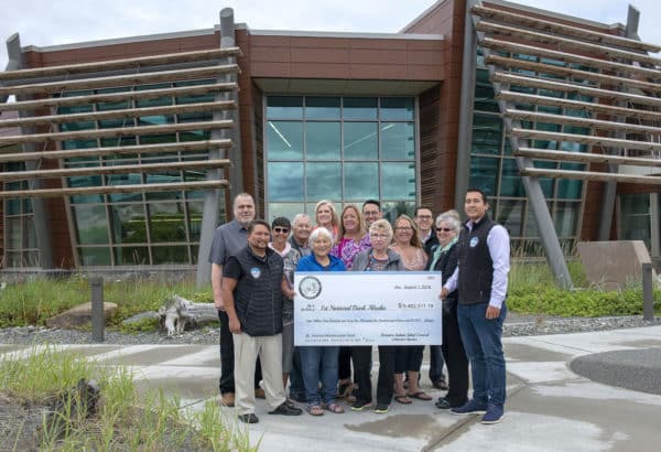 Members of the Tribal Council and Finance Committee pose July 27 with a ceremonial check at the Dena’ina Wellness Center. Pictured are Kenneth Oder, Council Chairperson Wayne Wilson Jr., Sharon Isaak, Council Member James O. Segura, Linda Ross, interim Executive Director Dawn Nelson, Council Secretary Diana Zirul, Ben Baldwin, Council Member Liisia Blizzard, Council Member Jennifer Showalter Yeoman, Director of Financial Services Michael Dixon, Council Vice-Chairperson Bernadine Atchison and Council Treasurer Clinton Lageson.